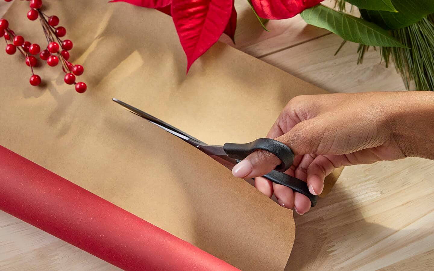 Person uses scissors to cut wrapping paper