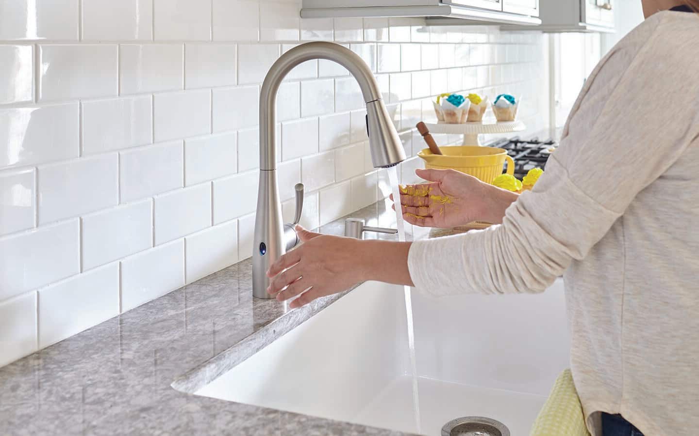 Someone using a smart, touchless kitchen faucet. Someone using a smart, touchless kitchen faucet.