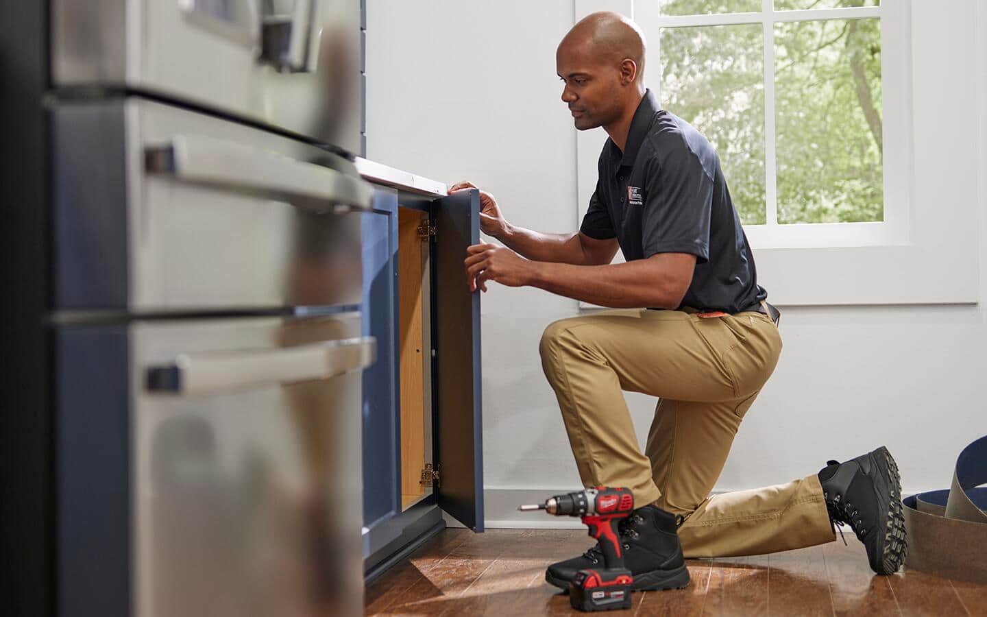 A professional from The Home Depot replacing the cabinet doors in a kitchen.