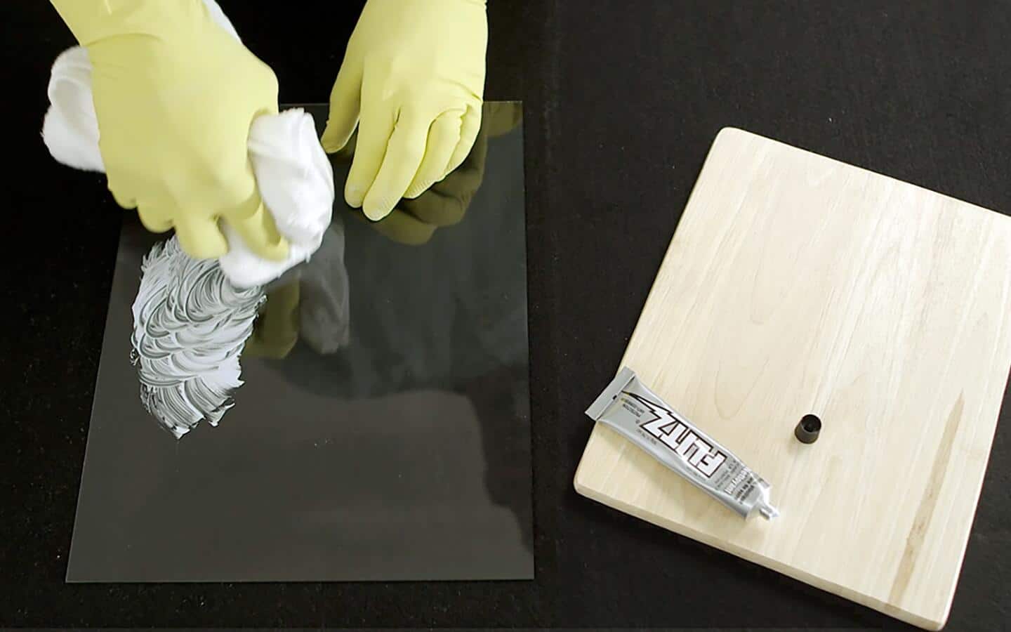 Metal polish being applied with a cloth to glass scratches.