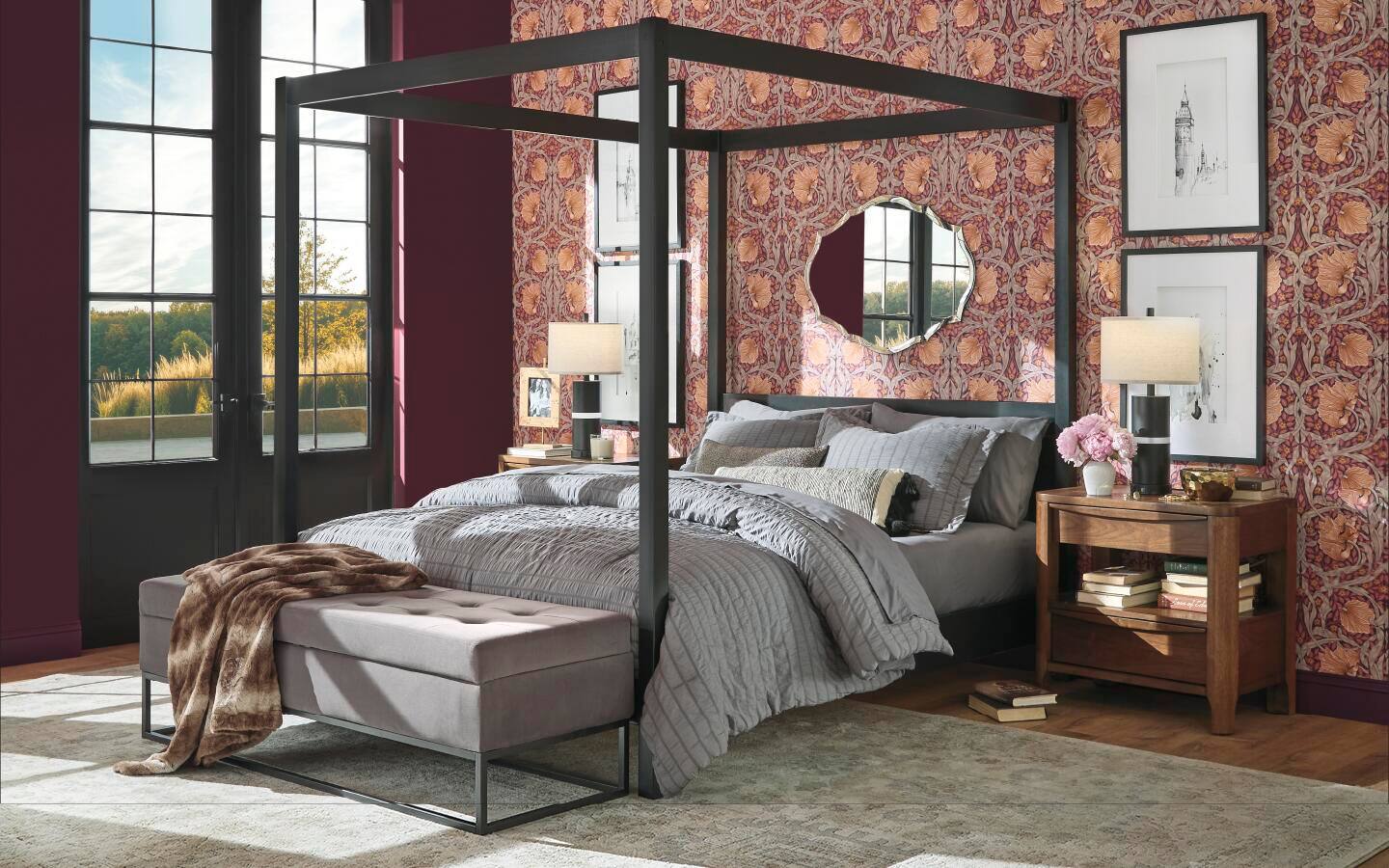 A king poster bed placed in front of bedroom wall covered in ornate wallpaper. A king poster bed placed in front of bedroom wall covered in ornate wallpaper.