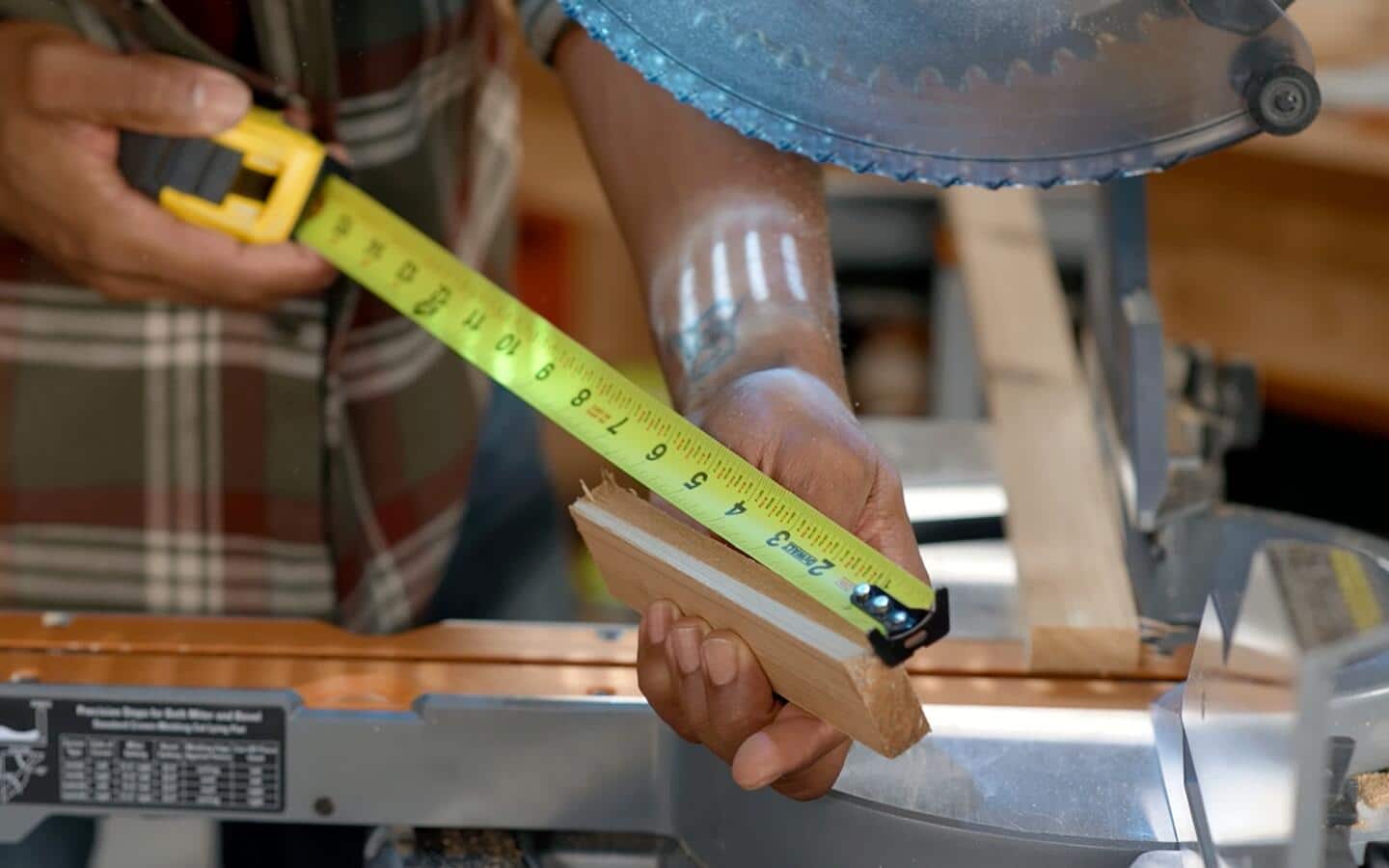 A tape measure is used to mark a piece of wood for a window box's handle.