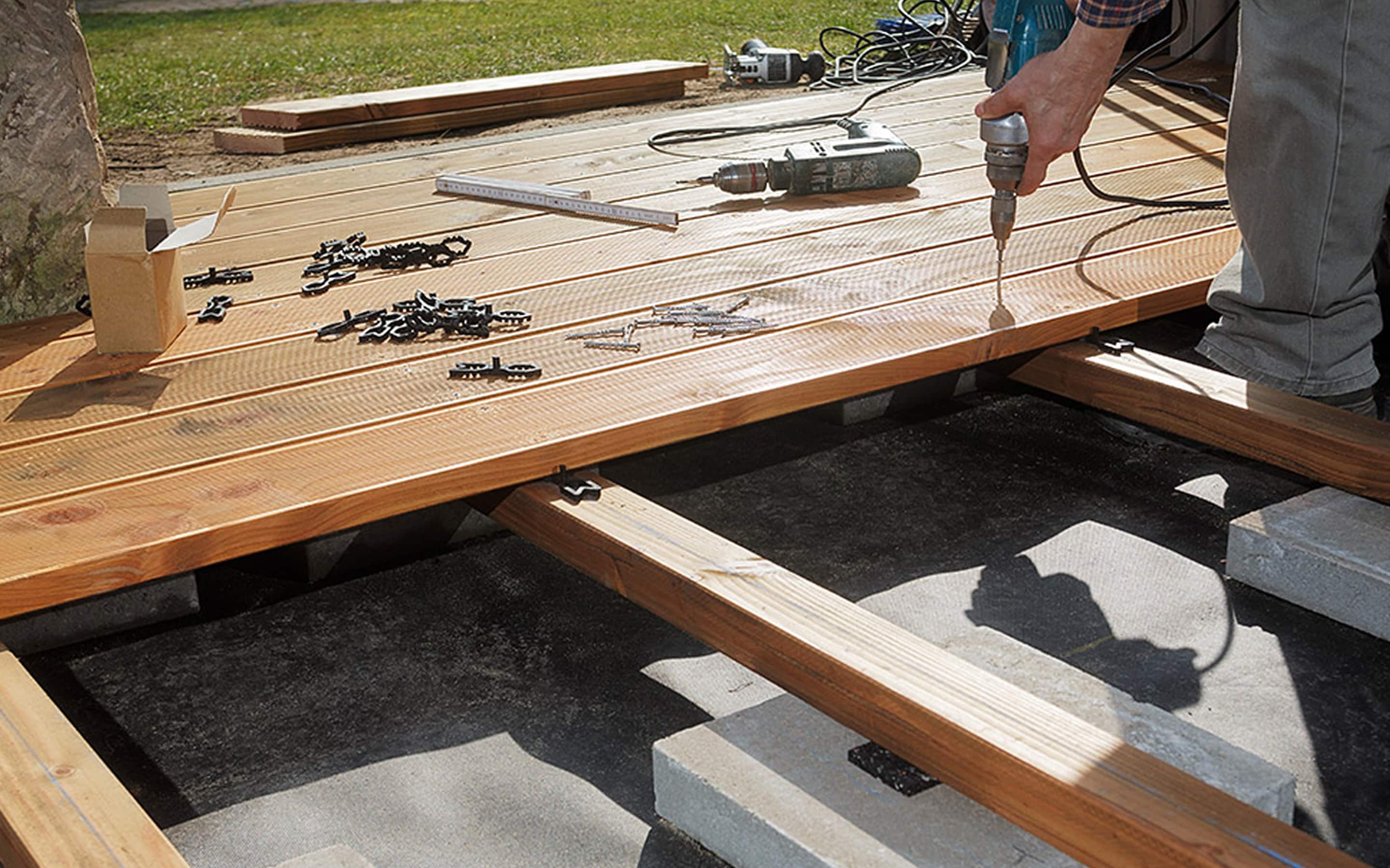 A Pro installing screws into wood panels for a deck. A Pro installing screws into wood panels for a deck.