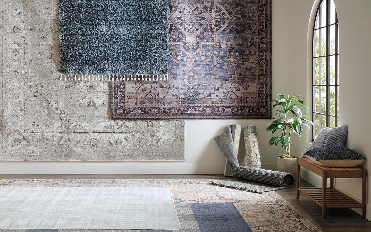 A living room with several options for rugs placed on the floor and walls to see how they work with the natural light in the room A living room with several options for rugs placed on the floor and walls to see how they work with the natural light in the room