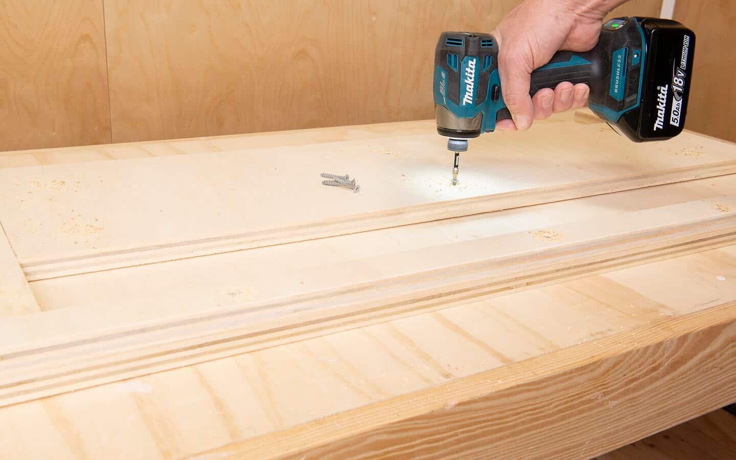 A screw being driven into the center support of a DIY soccer rebounder board, a battery powered impact driver is the tool being used. A screw being driven into the center support of a DIY soccer rebounder board, a battery powered impact driver is the tool being used.
