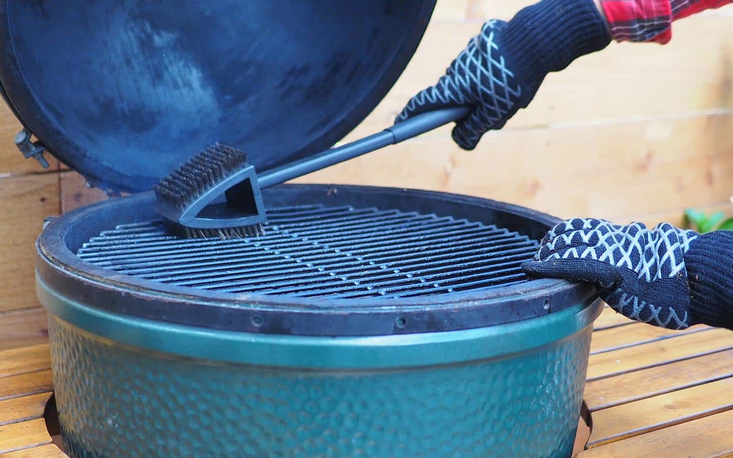Someone scrubbing the grates of a round grill. Someone scrubbing the grates of a round grill.