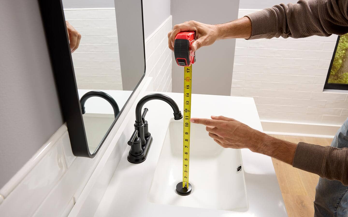 Measuring from the top of the drain plug to the bottom of the faucet outlet.