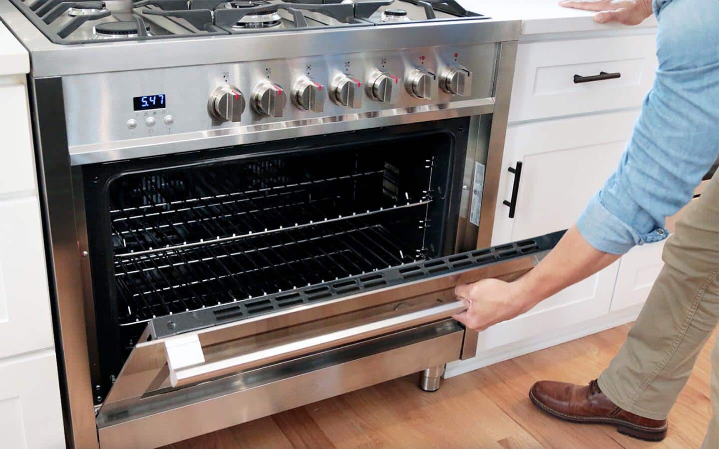 Someone opening a stainless steel oven door. Someone opening a stainless steel oven door.