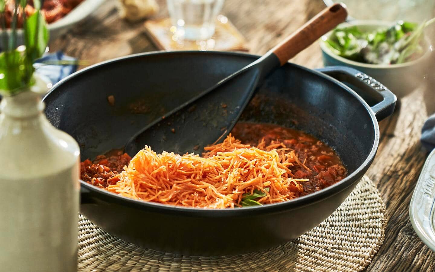 A meal being served in a wok on a table. A meal being served in a wok on a table.