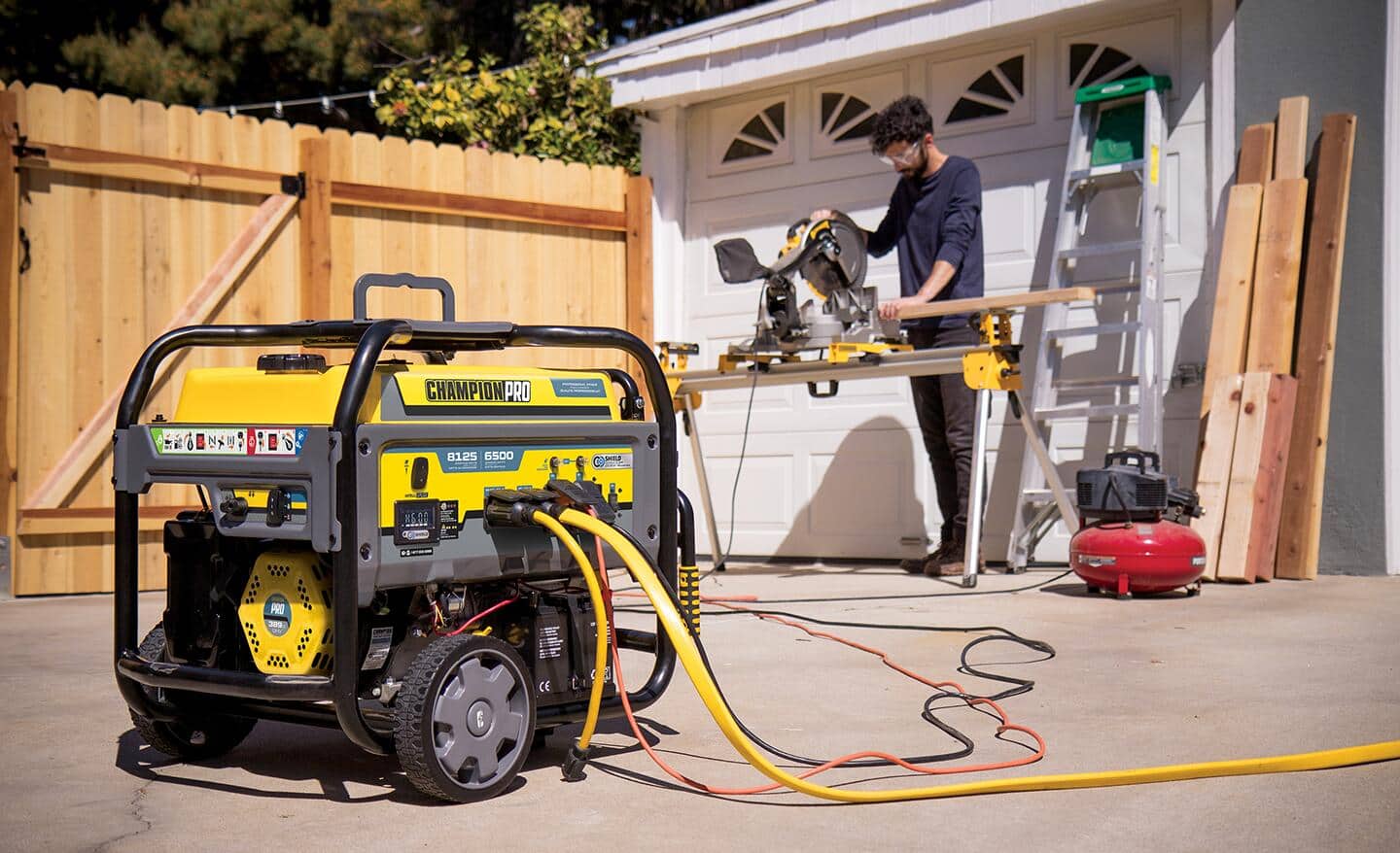 A man use a portable generator to power a saw in front of a garage door.