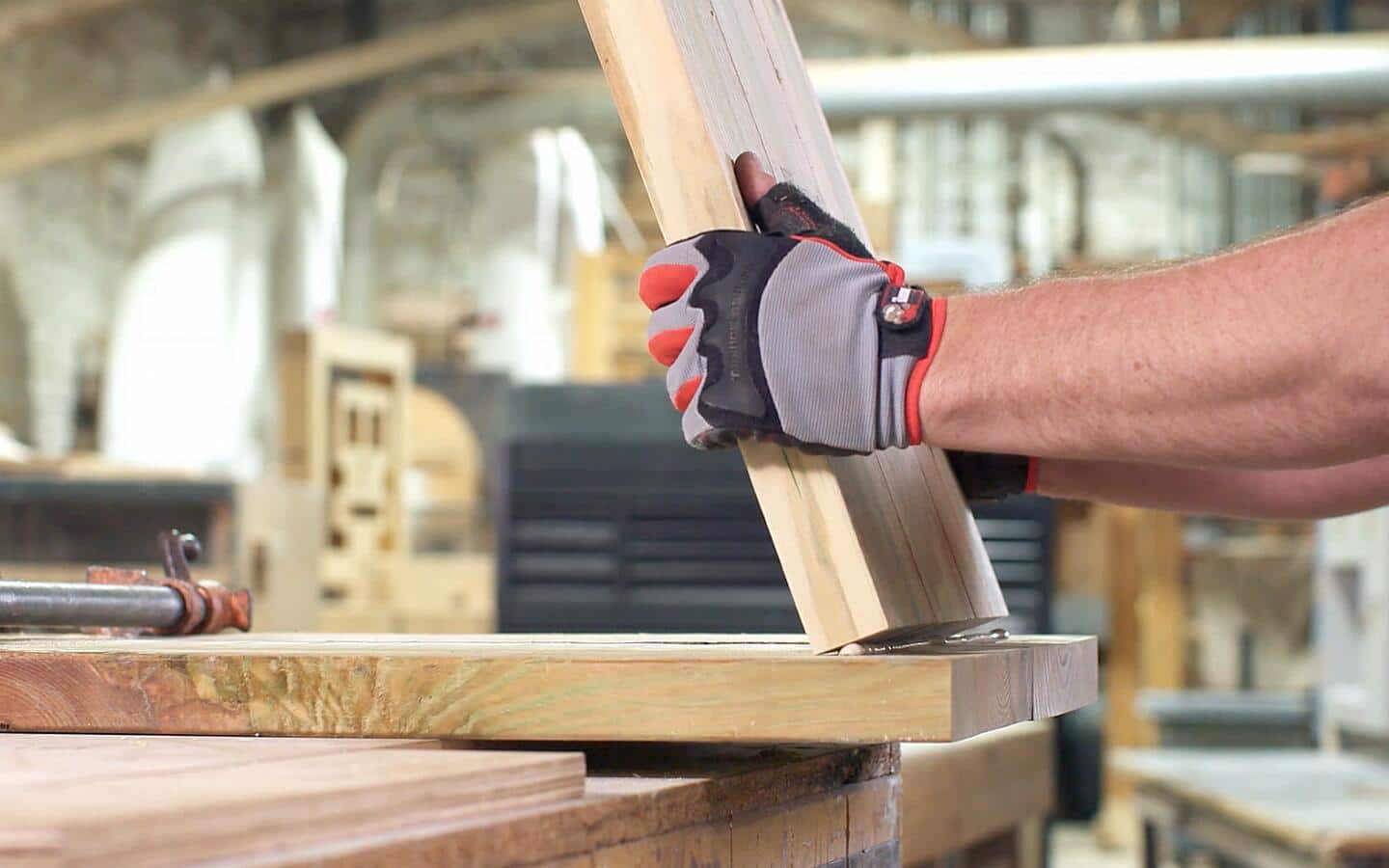 A glue-covered wood board being attached to another for an outdoor grill.