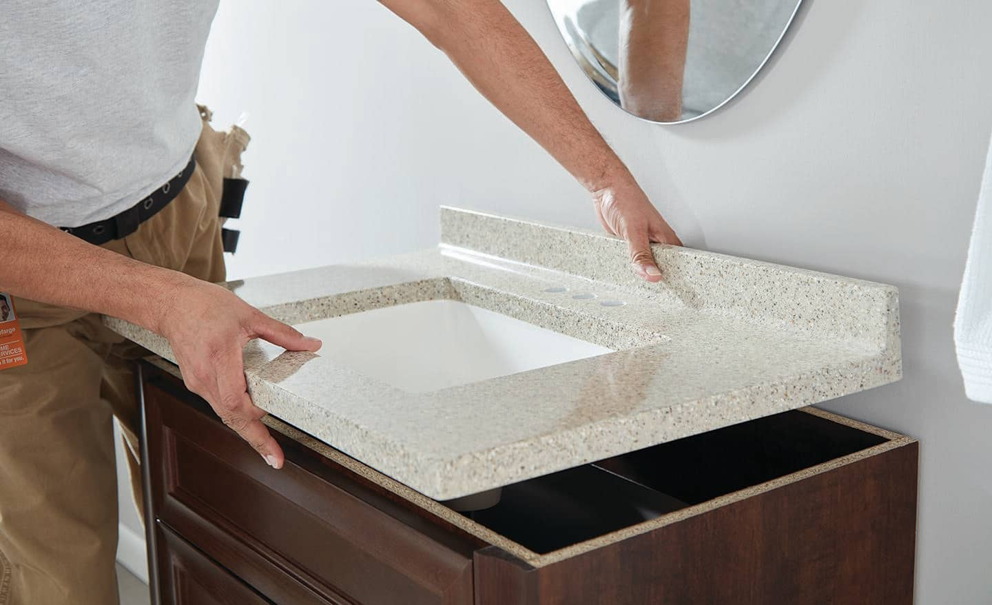 A new sink being installed on top of a bathroom vanity.