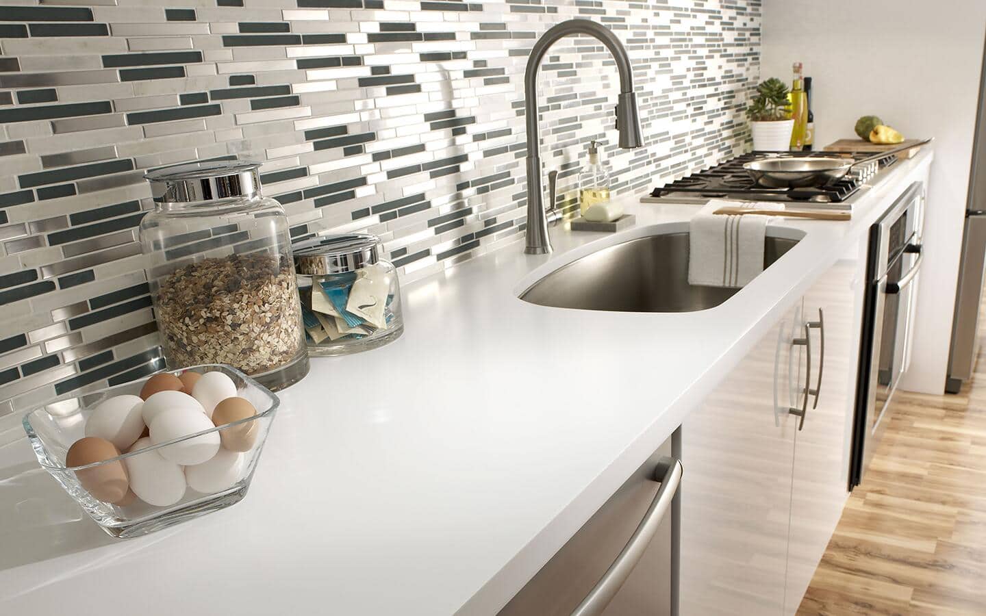 White solid surface countertop in a kitchen surround in a galley style kitchen