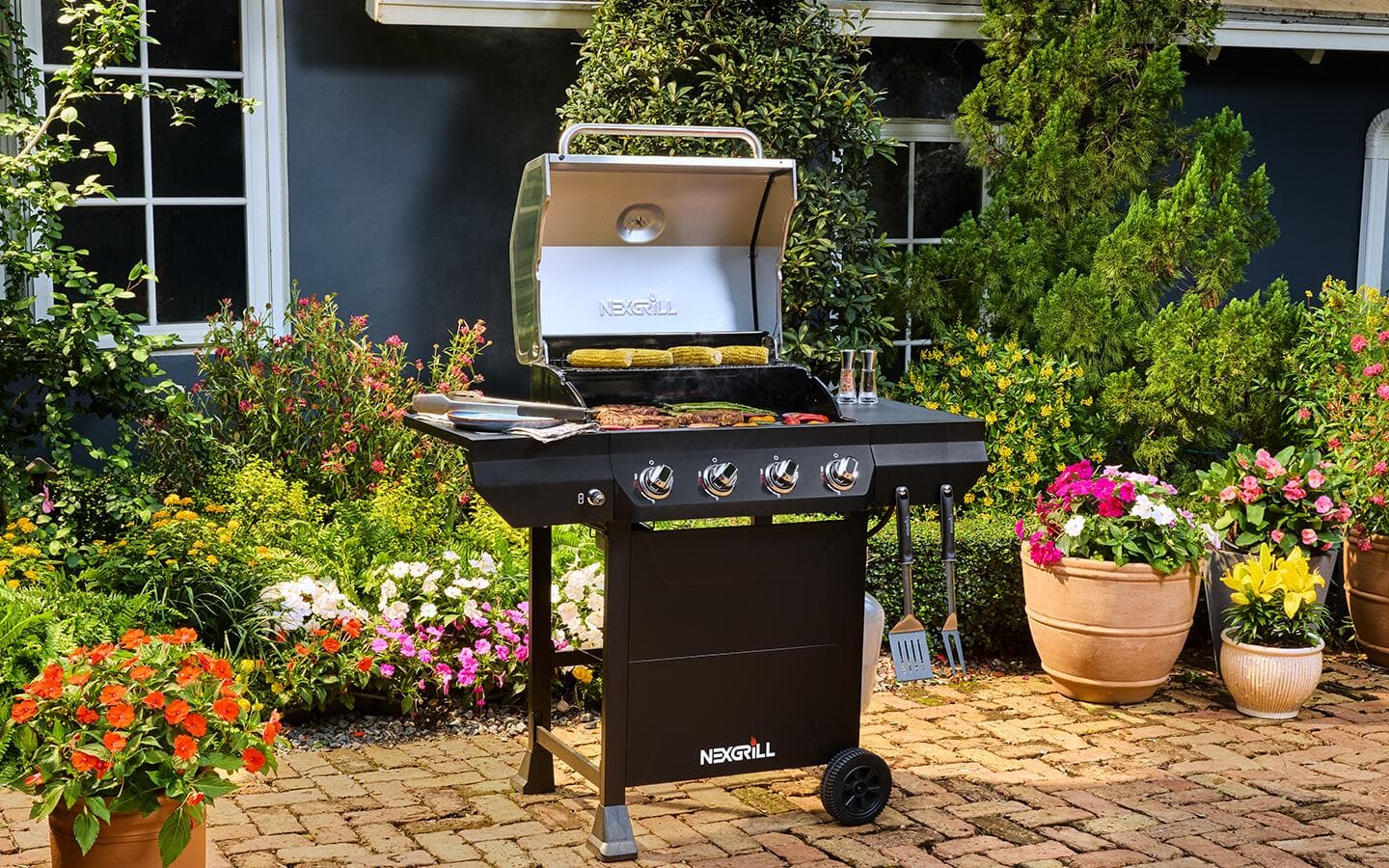 A backyard patio featuring a small grill