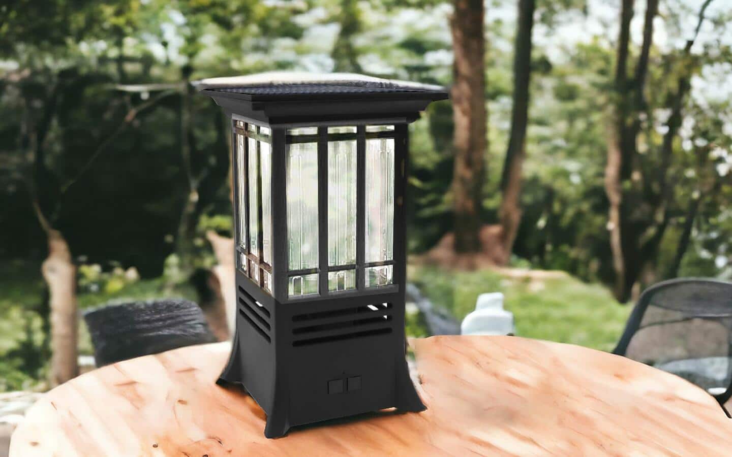 An electric insect repellent torch stands at the edge of a yard seen in soft focus. 