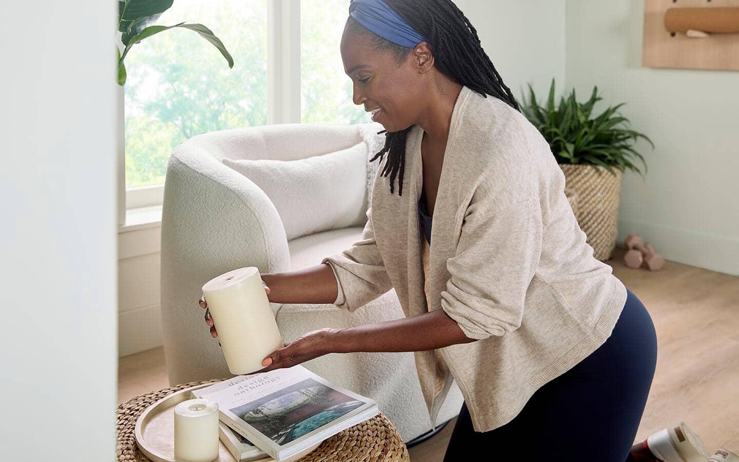 Woman placing scented candles on a tray. Woman placing scented candles on a tray.
