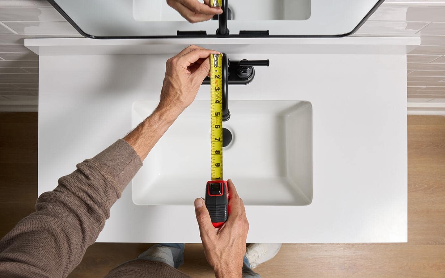 Measuring the reach of a bathroom faucet.