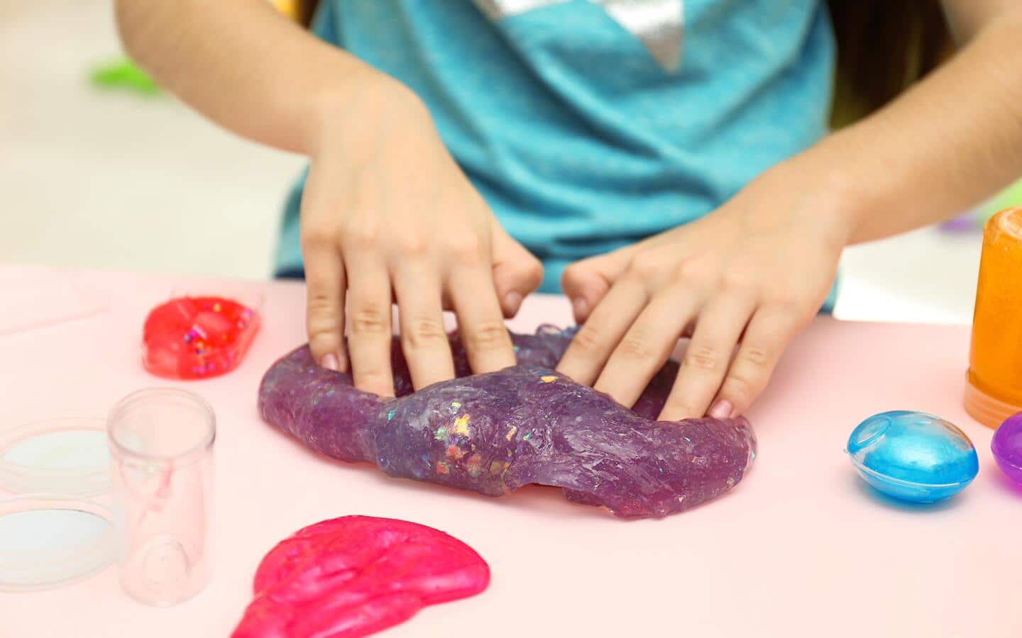 Child kneading purple slime. Child kneading purple slime.