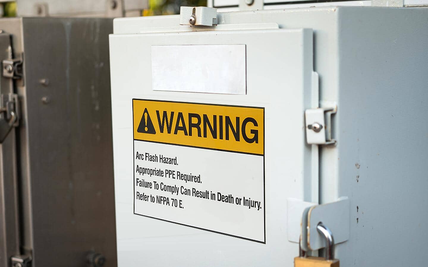 An electrical panel with an arc flash warning label. An electrical panel with an arc flash warning label.