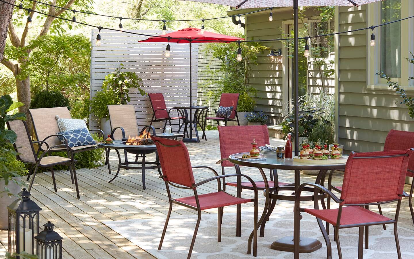 A backyard deck includes two sets of tables and chairs for outdoor dining. A backyard deck includes two sets of tables and chairs for outdoor dining.