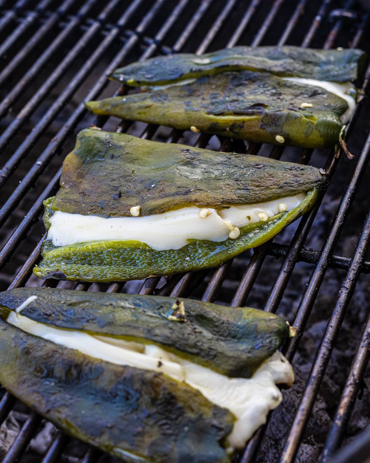 Poblano peppers stuffed with cheese on a grill. Poblano peppers stuffed with cheese on a grill.