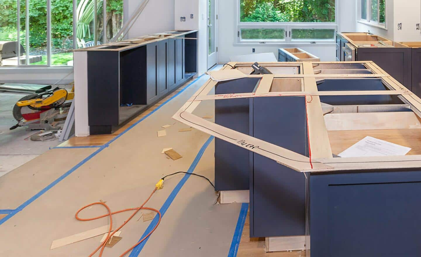 A paper drop cloth taped to a floor in a room with construction.