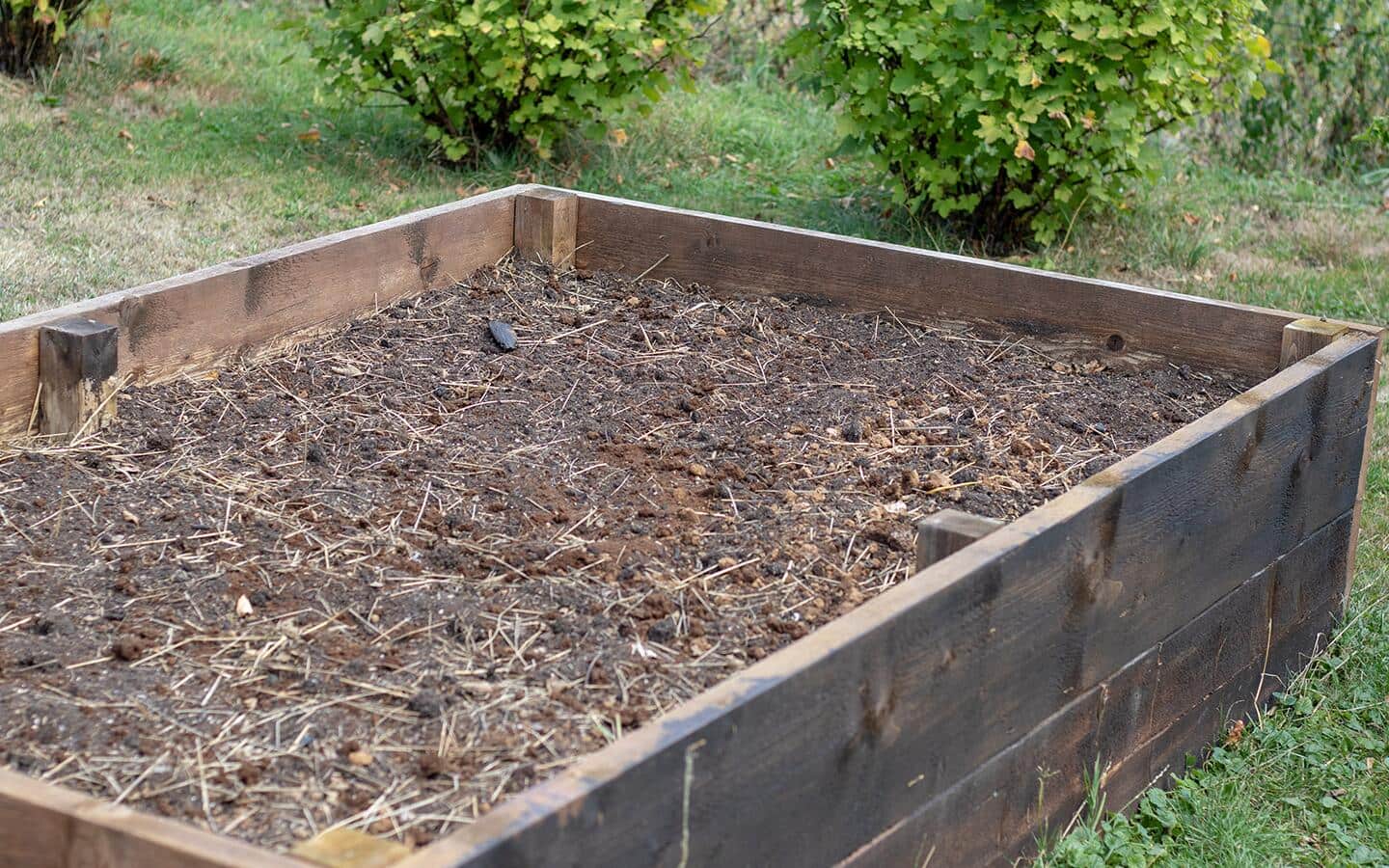 A raised garden bed filled with soil A raised garden bed filled with soil