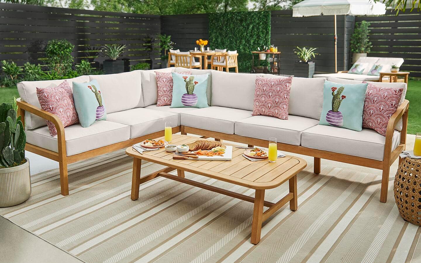 An outdoor rug on a backyard patio with outdoor seating.