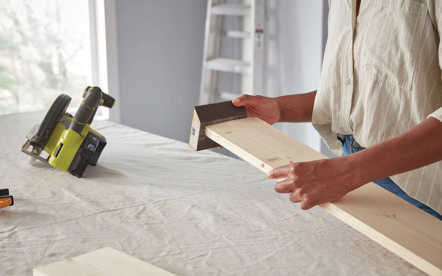 Someone sands boards for a coat rack.