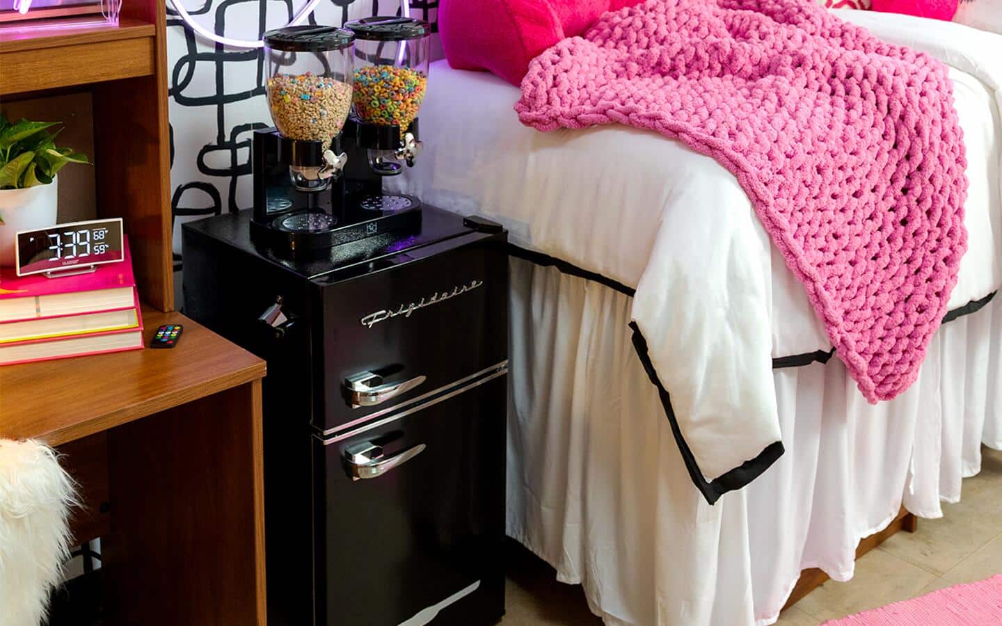 Snack dispensers sitting on top of a mini fridge in a college dorm room. Snack dispensers sitting on top of a mini fridge in a college dorm room.