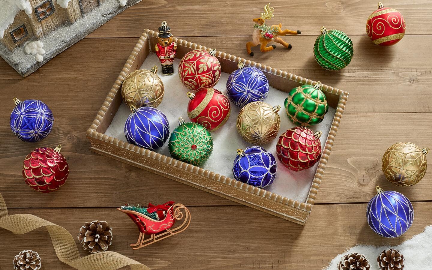 Various Christmas ornaments of multiple colors laid out on the floor.