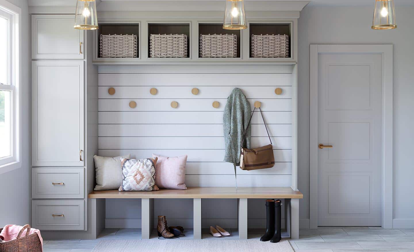 An organized mudroom at the back door of a house. An organized mudroom at the back door of a house.