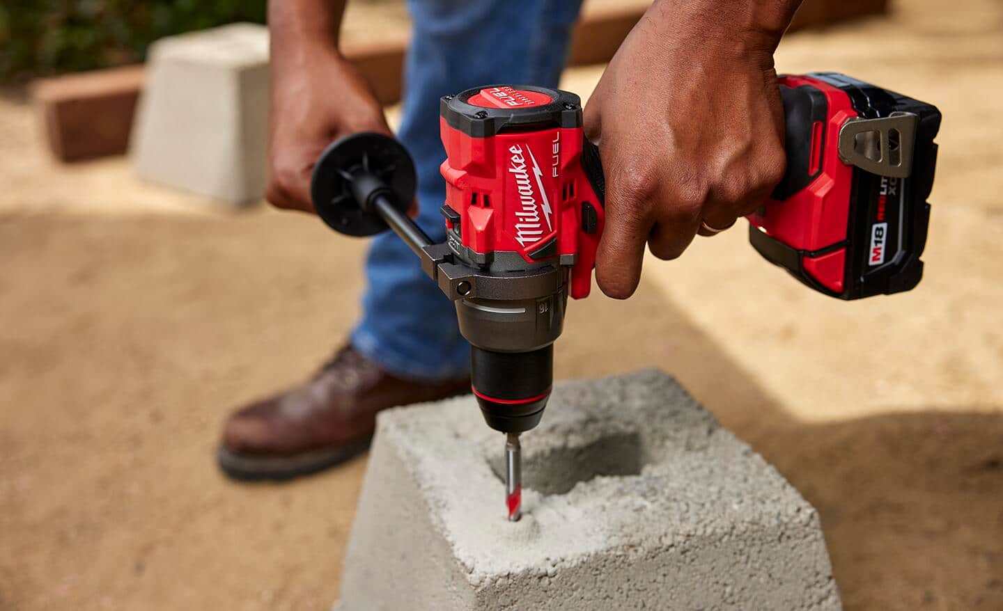 A man drilling into a concrete block.