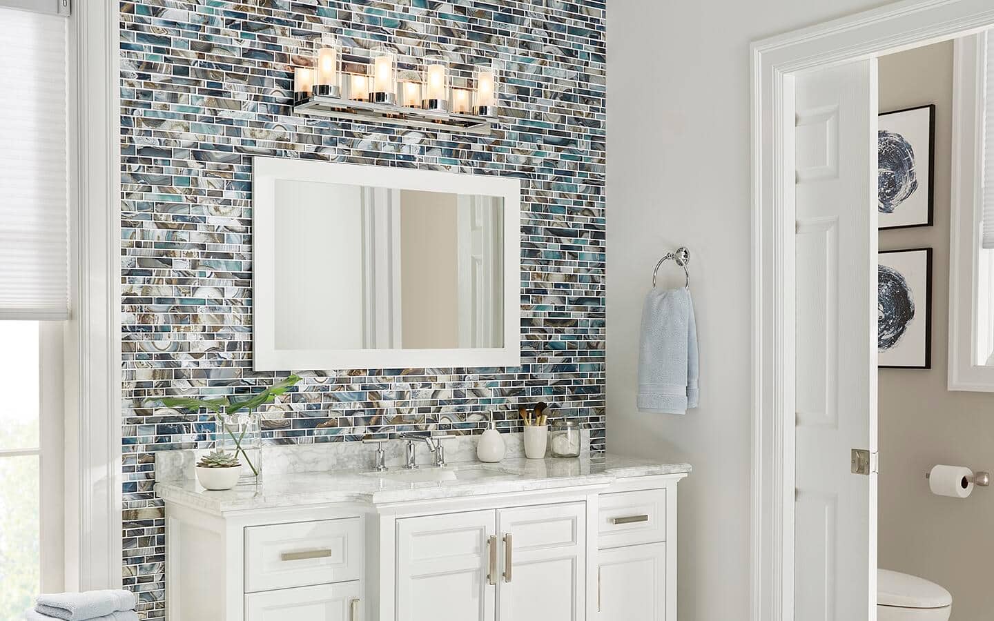 A white vanity and mirror with a colorful backsplash. A white vanity and mirror with a colorful backsplash.