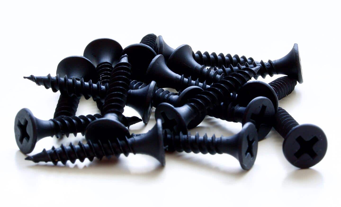 A pile of coarse drywall screws sitting on a table. A pile of coarse drywall screws sitting on a table.