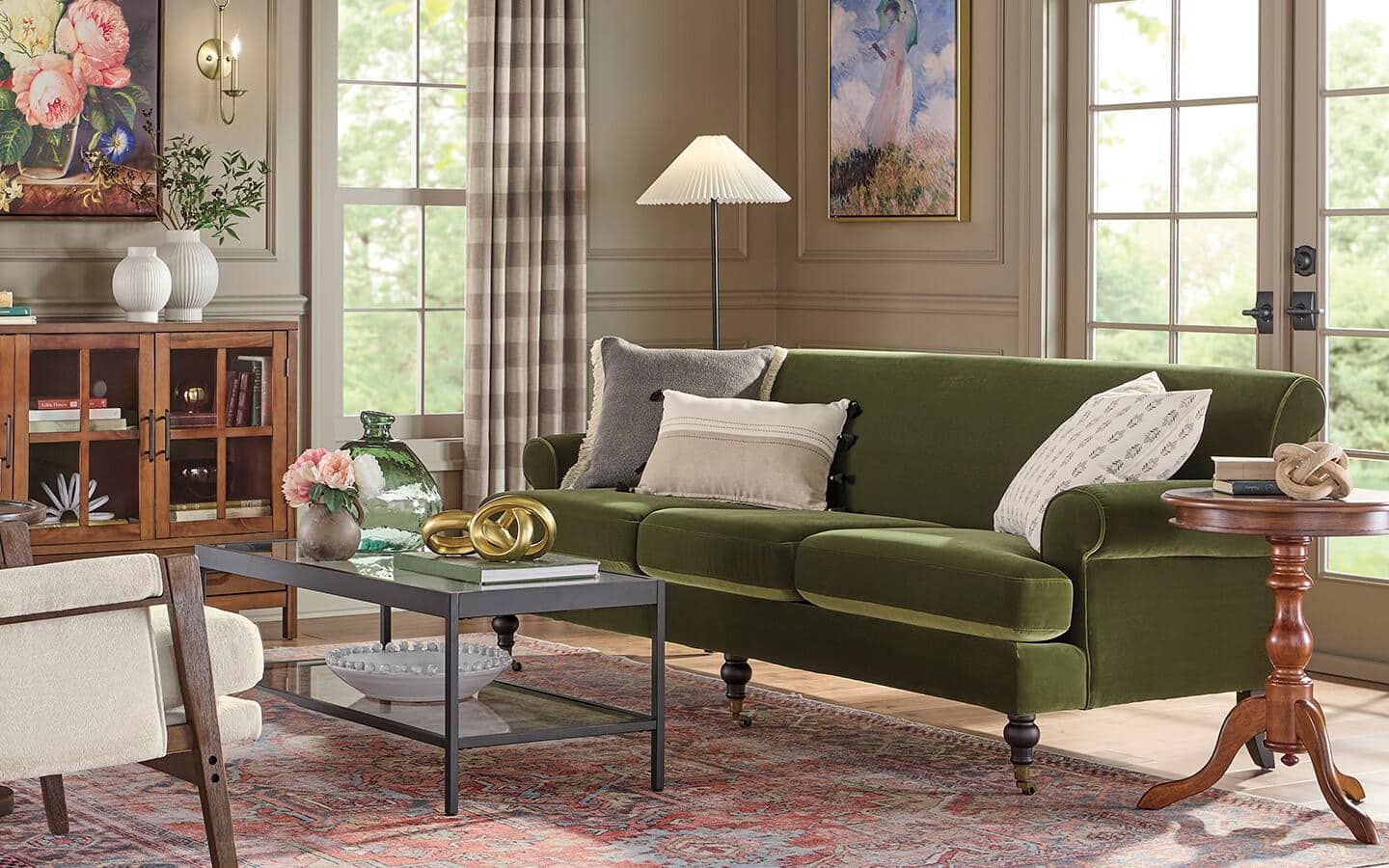 A green velvet English-Style roll arm sofa placed in the corner of a living room. A green velvet English-Style roll arm sofa placed in the corner of a living room.