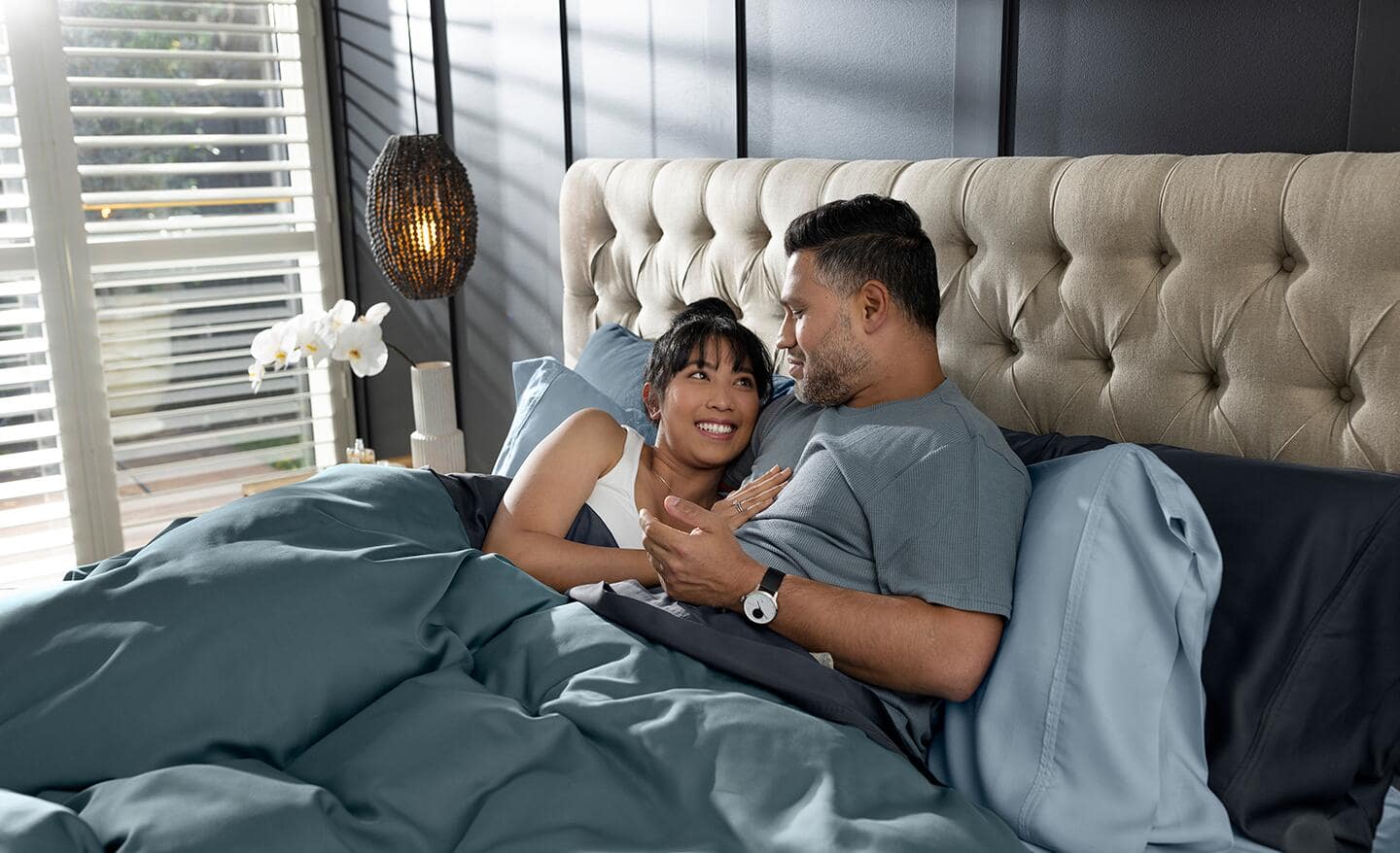 A couple relaxing and talking in a king bed. A couple relaxing and talking in a king bed.