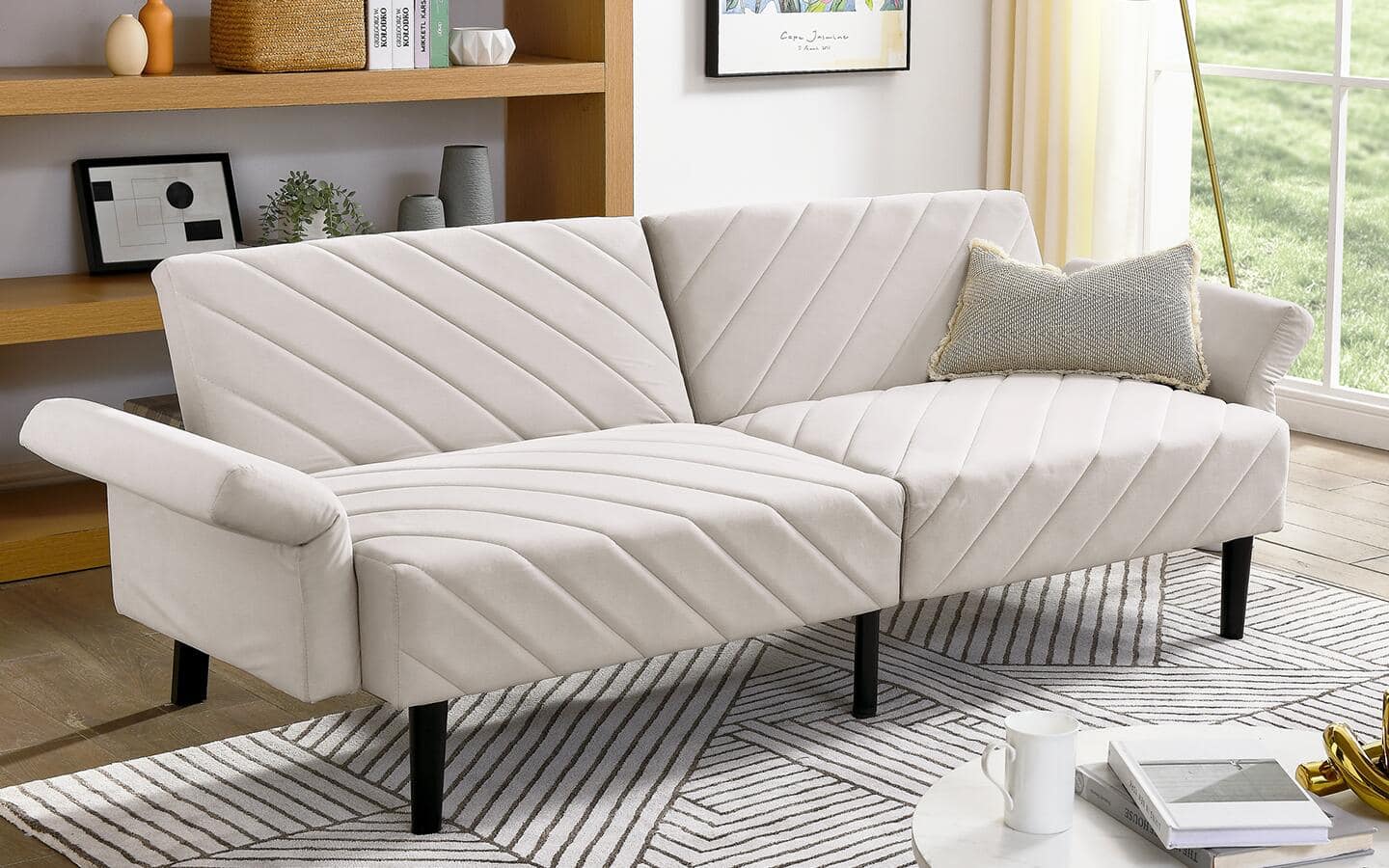 A white, two-seater futon placed next to a living room window. A white, two-seater futon placed next to a living room window.