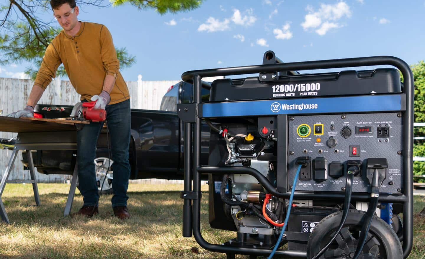 A man uses a portable generator in his yard. 