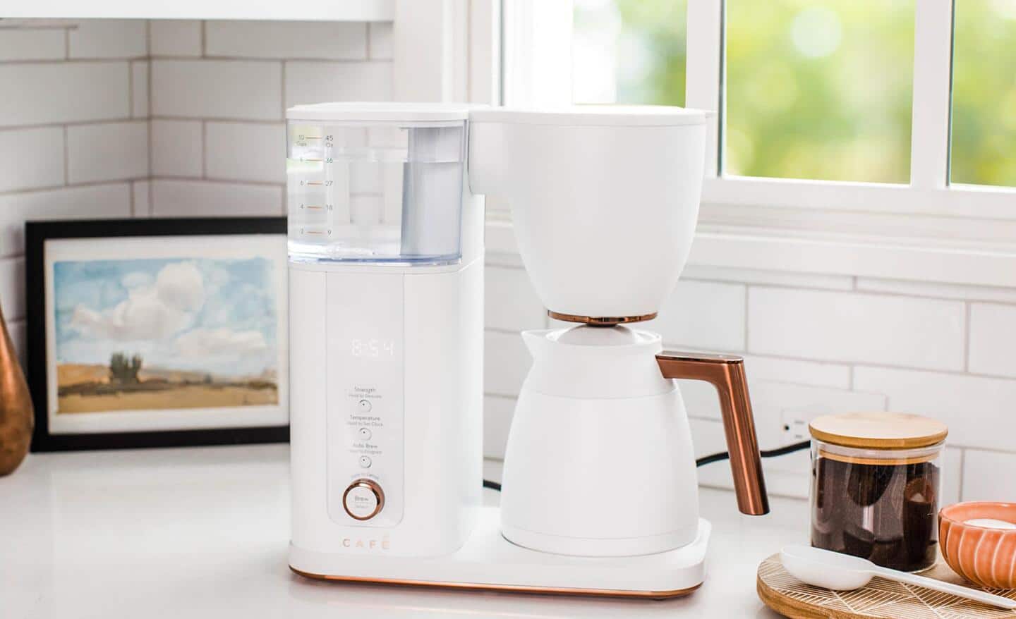 An white automatic coffee maker on a kitchen counter. An white automatic coffee maker on a kitchen counter.