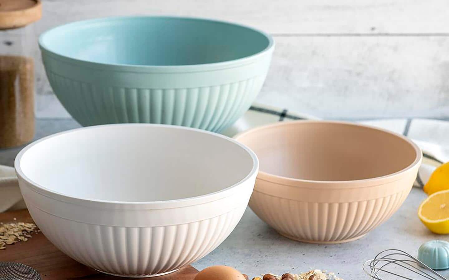 Three ceramic mixing bowls sitting empty on a kitchen countertop.