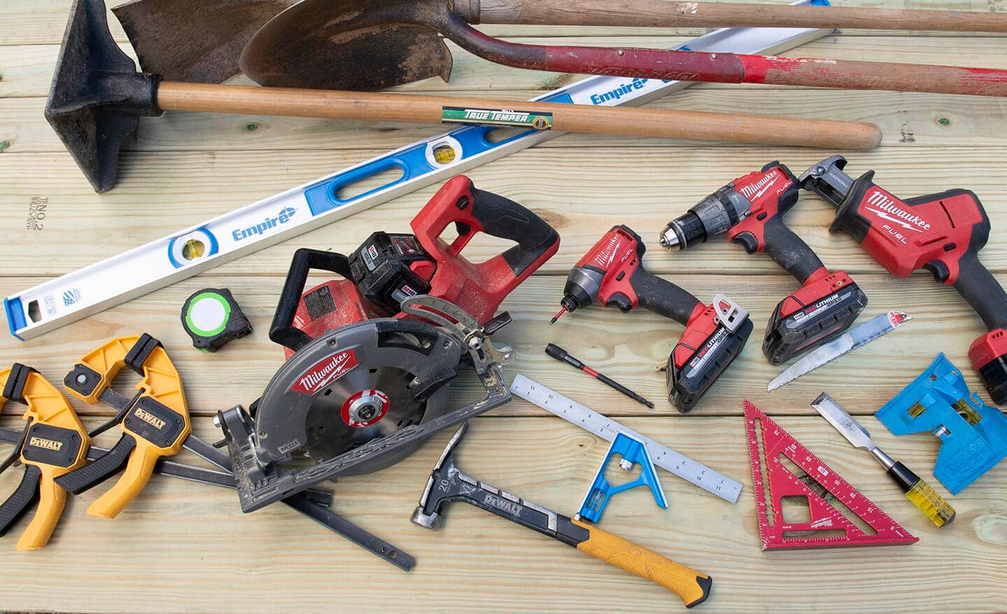 A collection of some tools used in this project, clamps, circular saw, 48 inch level, post level, squares, drill, impact driver, reciprocating saw, chisel, hammer, tape measure, shovels and tamper.