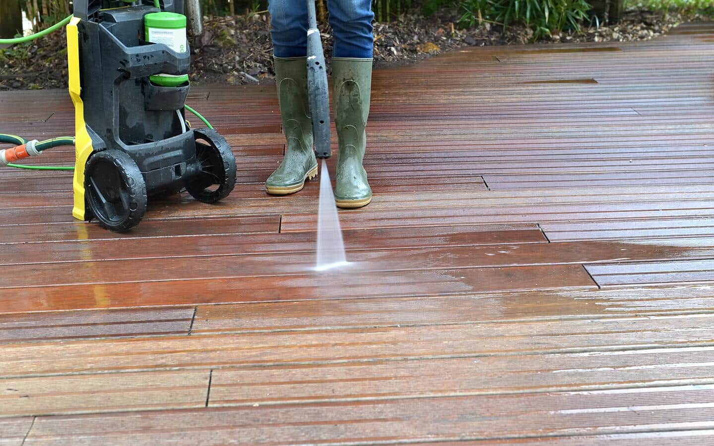 A person pressure washing a driveway. A person pressure washing a driveway.