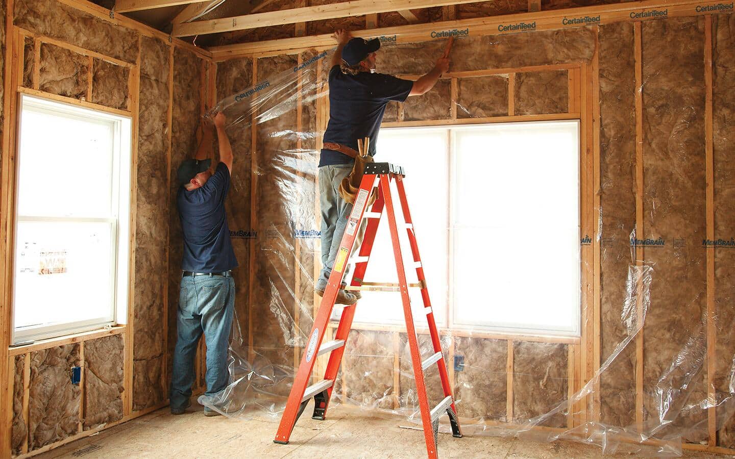Two people install plastic vapor barrier. Two people install plastic vapor barrier.