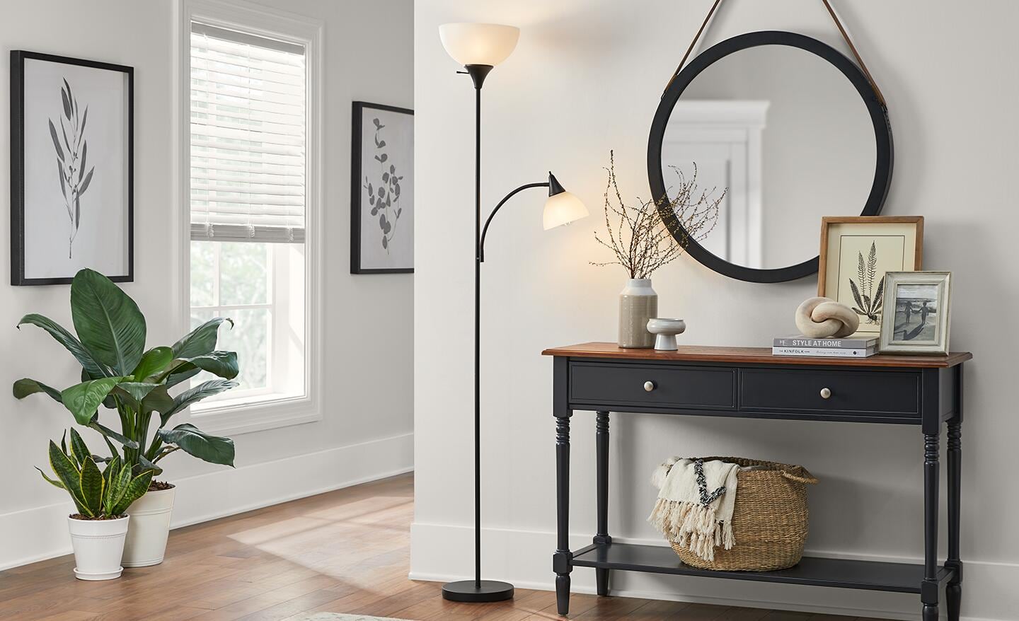 A torchiere lamp sits next to an entryway table. 