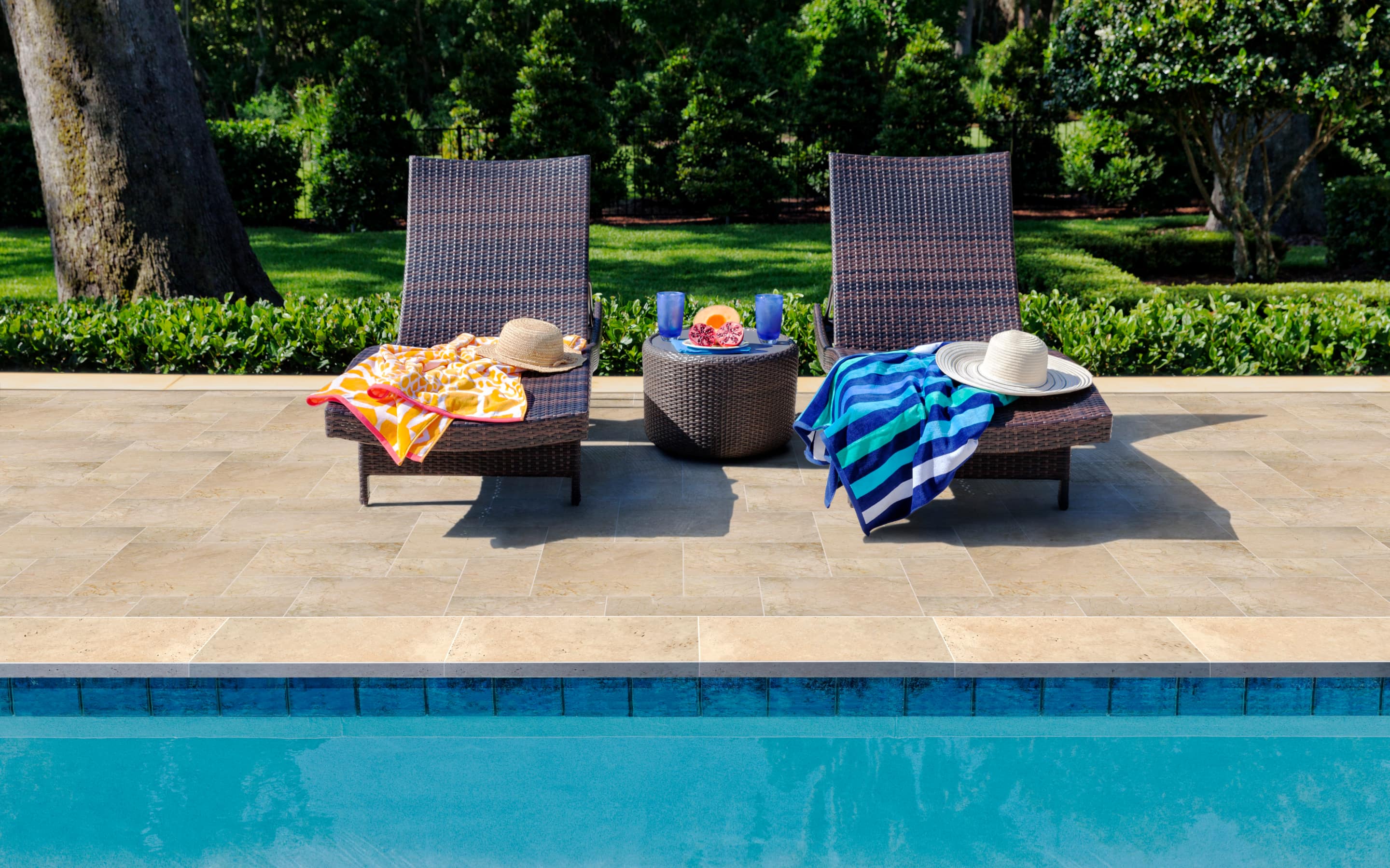 Two pool chairs on a pool deck.