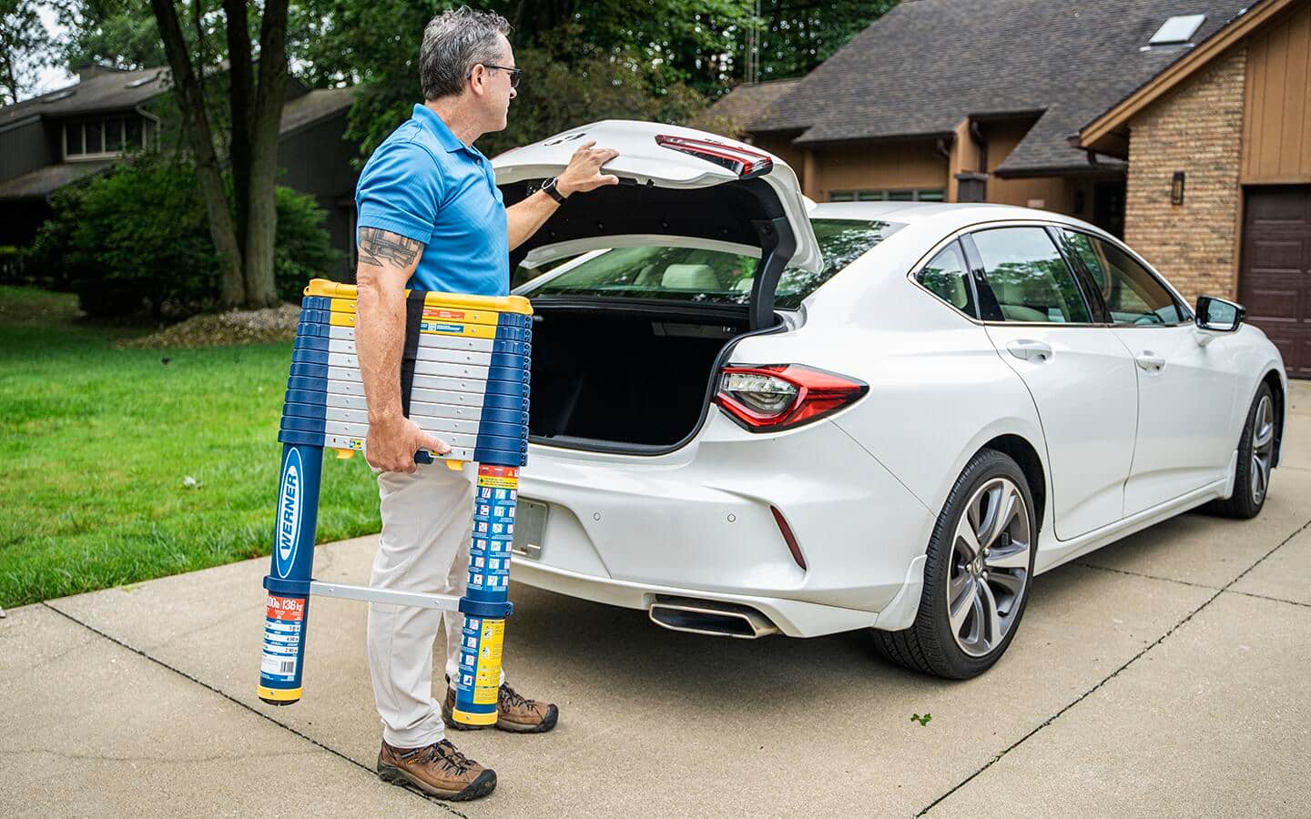 An individual takes a telescoping ladder out of a white car's trunk. An individual takes a telescoping ladder out of a white car's trunk.