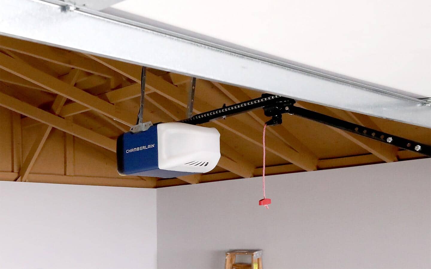 A chain drive garage door opener hangs from a ceiling.