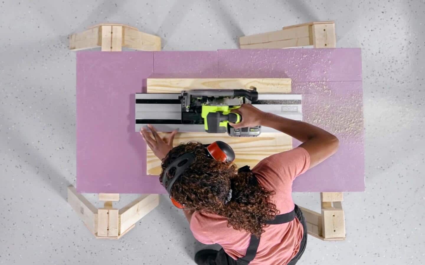 A person in headphones uses a circular saw to cut a piece of wood for a shoe rack. A person in headphones uses a circular saw to cut a piece of wood for a shoe rack.