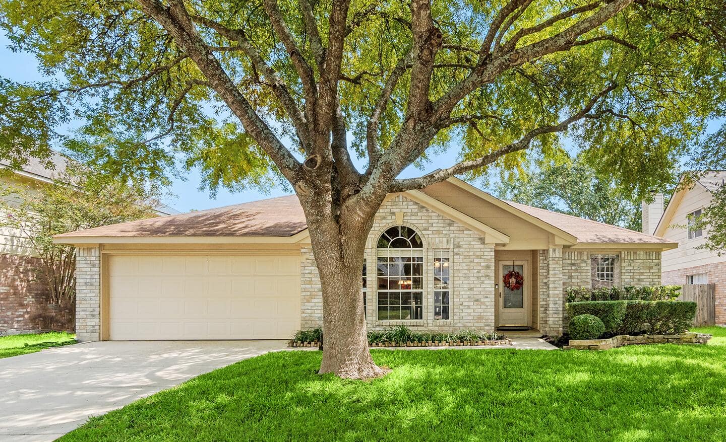 A house with a tree in the front yard.